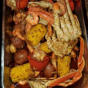 crab legs, corn, potatoes, and corn on the cob