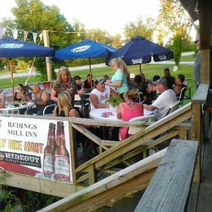 a group of people sitting at tables outside