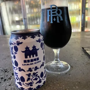 a glass of beer next to a can