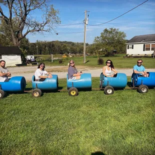 a group of people riding on blue barrels