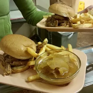 A side of baked apples with pulled pork sandwich and fries.