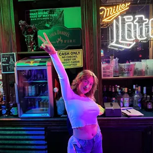 a woman standing in front of a bar