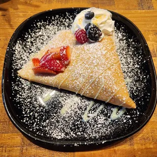 a crepe on a black plate