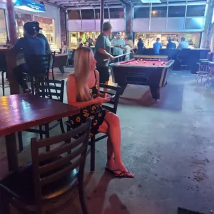 a woman sitting at a pool table