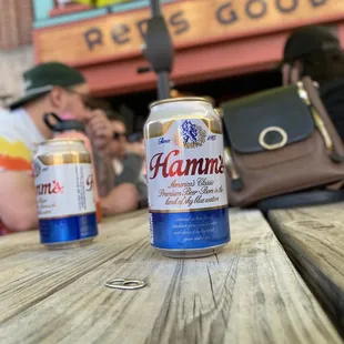 two cans of beer on a picnic table