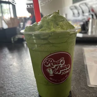 a green smoothie in a plastic cup