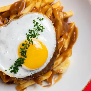 a fried egg on top of french fries