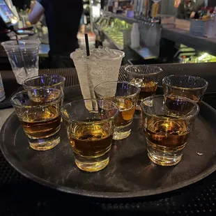 a tray of glasses of whiskey