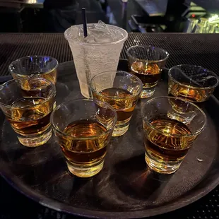 a tray of glasses of whiskey