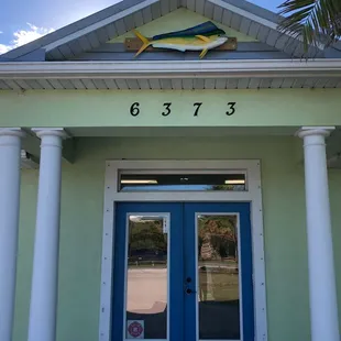 The front door, set back from the street with ample parking out front.