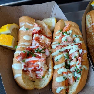 Lobster rolls with pineapple mayo and cilantro jalapeno on a brioche split top bun.