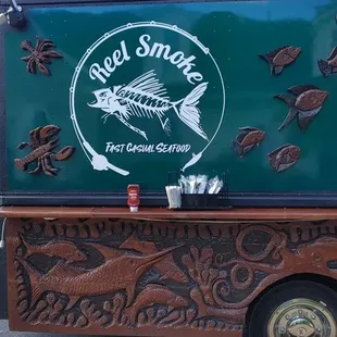 a green food truck with fish on it