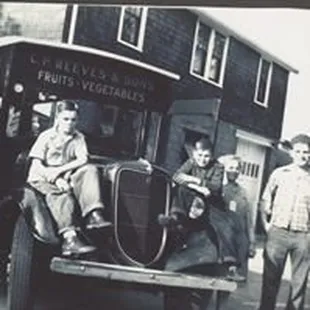 a group of men standing in front of a truck
