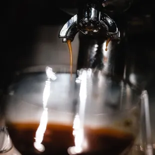 a coffee being poured into a glass