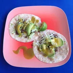 Carne asada tacos with lettuce and avocado, lime juice and of course, con salsa verde.