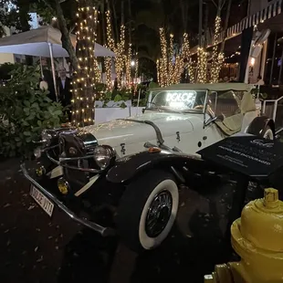 a white car parked next to a yellow fire hydrant