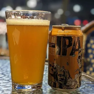 a glass of beer and a can on a table