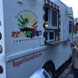 a woman standing in front of a food truck