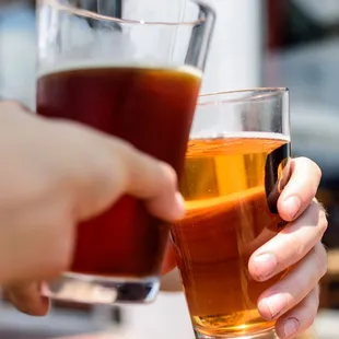 a close up of a person holding a glass of beer