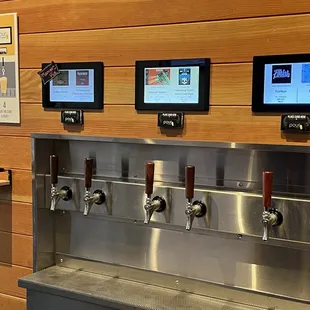 a row of beer taps on a wall