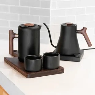 a teapot and two cups on a tray