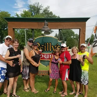 a group of people standing in front of a sign