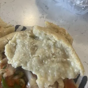 No tiene relleno la pupusa es nada mas masa! Aparte el curtido no sirve es nada mas repollo en agua