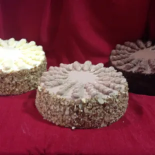 three cakes on a red cloth