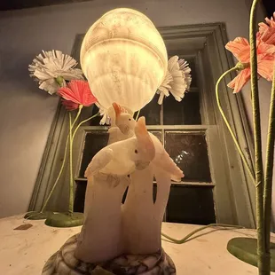 a table with a lamp and flowers