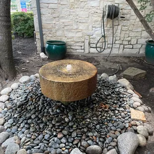 a stone fountain surrounded by rocks