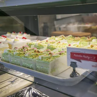 a variety of cakes in a display case