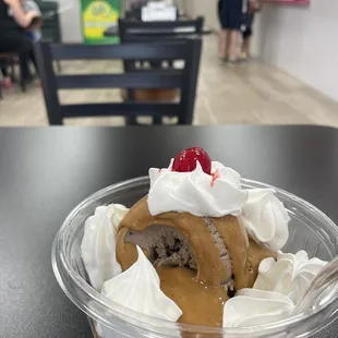 Peanut butter chocolate brownie hard packed ice cream sundae with peanut butter, whipped cream, and a cherry. This is a small.