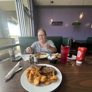 a woman sitting at a table with a plate of food