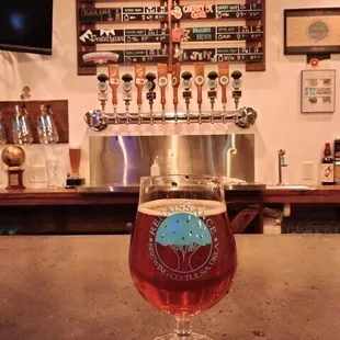 a glass of beer on a bar