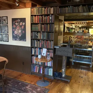a table and chairs in front of a bookshelf