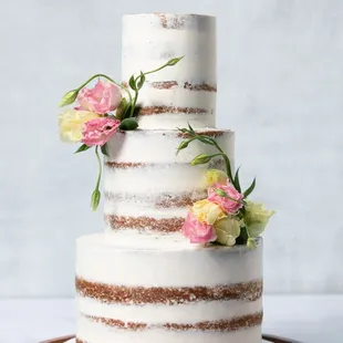 a three tiered cake with flowers on top