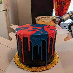 Red velvet cake with cream cheese layers; black buttercream with red/blue icing.
