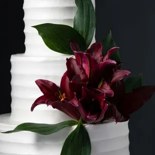 a white wedding cake with red flowers