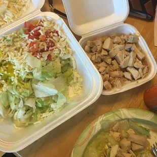 Grilled chicken salad with chicken on the side meant to say cheese.