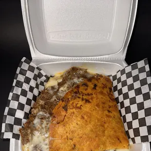 a slice of pizza in a styrofoam container