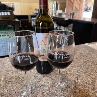 two glasses of wine and a bottle of wine