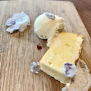 a piece of cake and ice cream on a cutting board