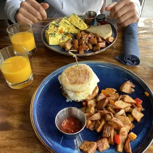 Breakfast sandwich with chicken sausage, potatoes frittata and sourdough bread, orange juice