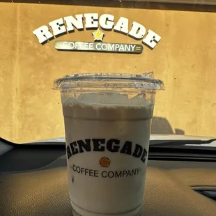 a cup of coffee on the dashboard of a car