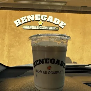 a cup of coffee on the dashboard of a car