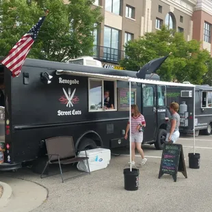 a black food truck parked in a parking lot