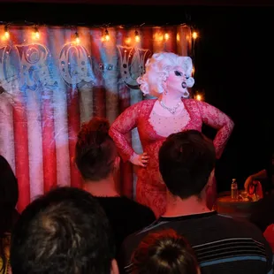 a drag queen performing in front of a crowd