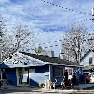a blue building with people walking by