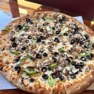 Medium pizza with Alfredo sauce and topped with bell pepper olives and mushrooms