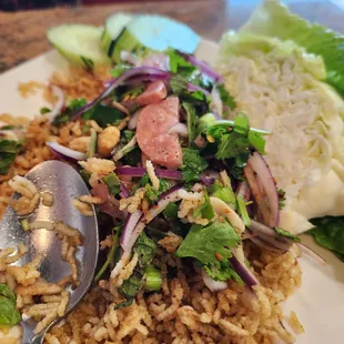 Minced issan sausage mixed with green onion, fresh chili, ginger, peanuts, crispy rice and lime juice